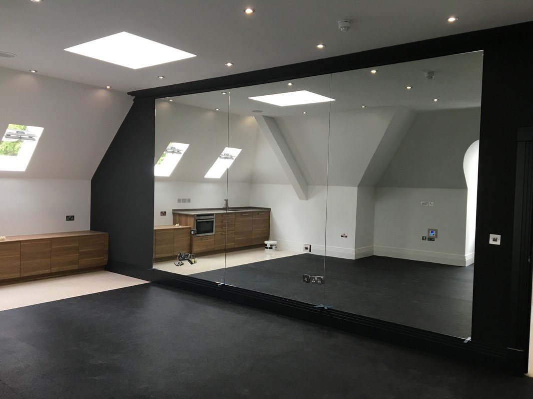 Frameless glass wall dividing loft conversion in Mill Hill